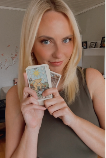 Katrin von Seelengeflüster mit einer Tarotkarte in der Hand welche der Stern ist
